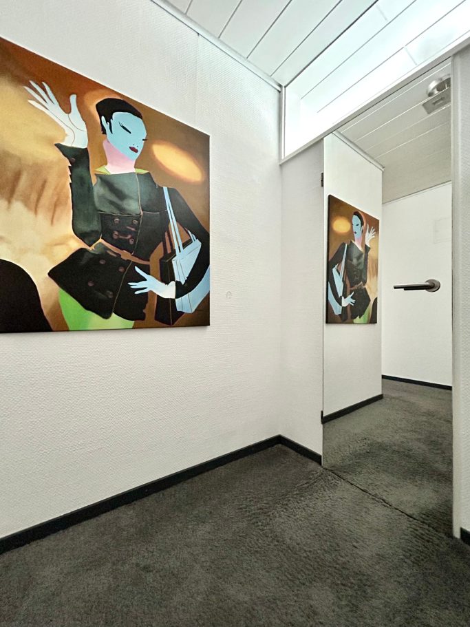 Moderne Kunstwerke an Wänden eines schlichten Flures mit grauem Boden.