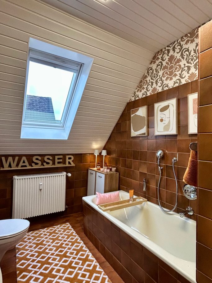 Modernes Badezimmer mit braunen Fliesen, Wanne und Fenster. Dekorative Wandgestaltung.